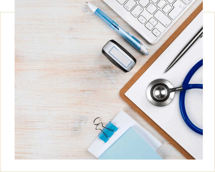 A desk with a stethoscope, pen and mouse.